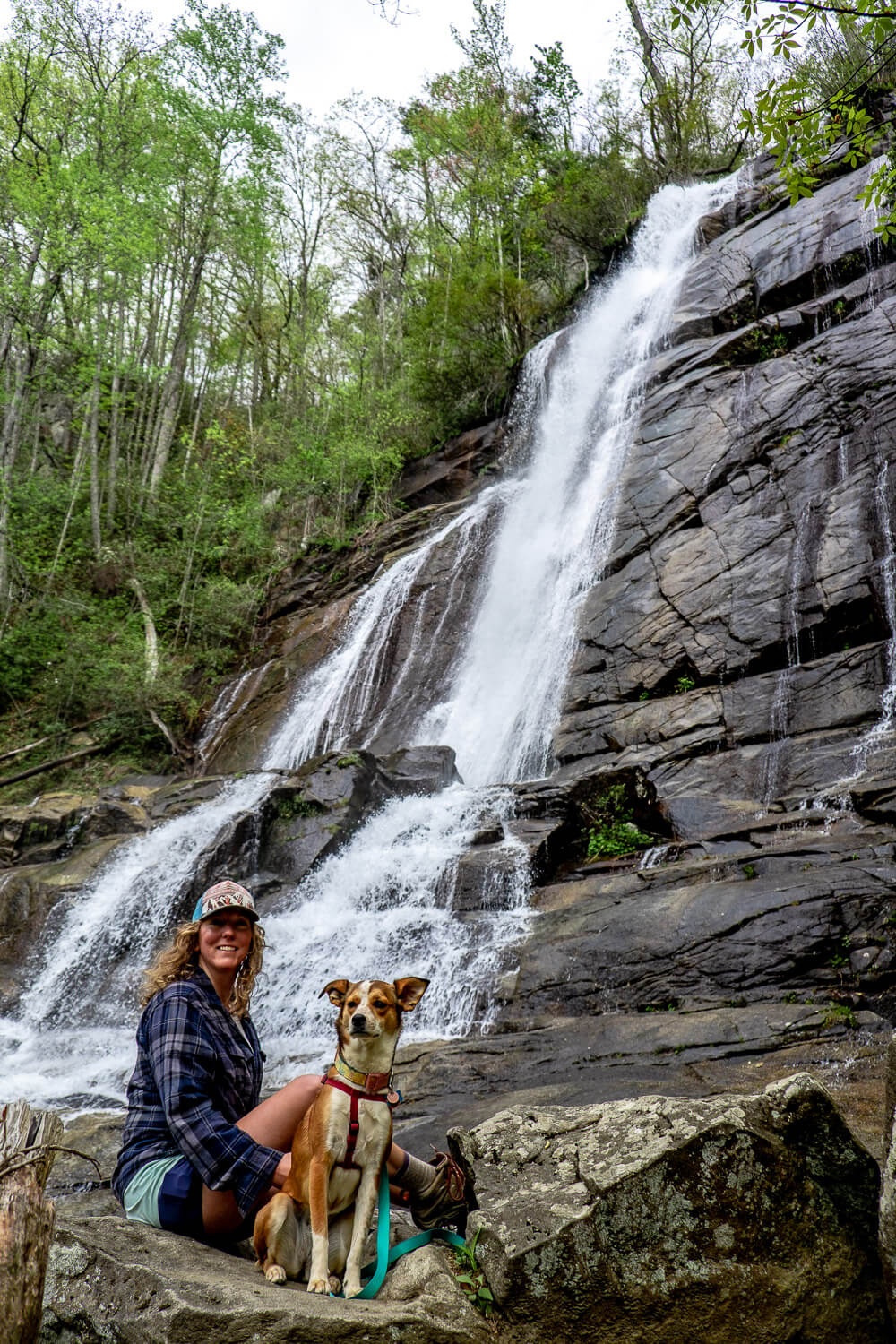 woman and dog in front of upper tier of falls creek falls